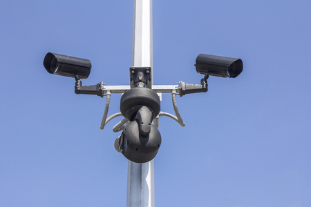 Three Security cameras on blue sky background の写真素材