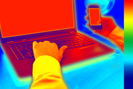Infrared thermography image showing the heat and radiation of Notebook and smartphones in the officeの写真素材