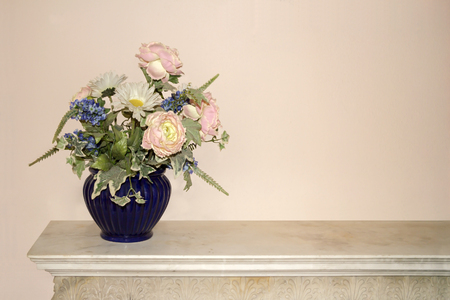 Blue vase full of colorful flowers on a commodeの写真素材
