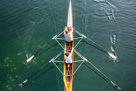 Two young boys in a boat, paddles on the tranquil lake 