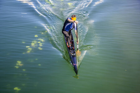 Man in a canoe, rowing on the tranquil lakeの写真素材