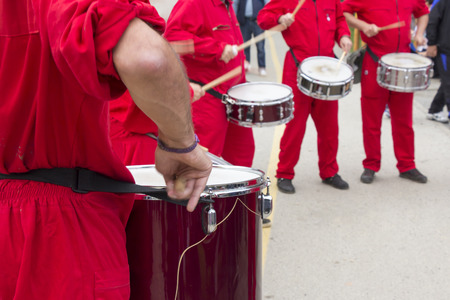 Four drummers in red overalls drumming on the streets of the cityの写真素材