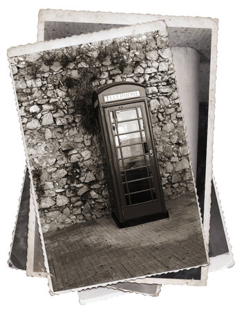 Vintage photos old telephone box on the street in front of stone wallの写真素材