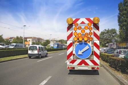 Road maintenance car signals detour due to roadworksの写真素材