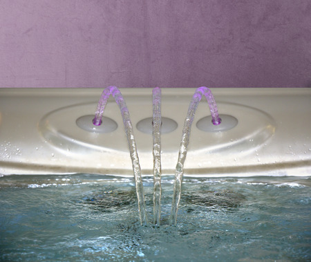 bathtub Bathtub filling up with clean water from a three faucetの写真素材