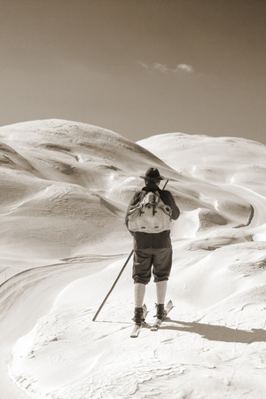 Old skier with traditional old wooden skis and backpackの写真素材