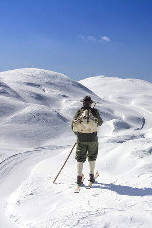 Old skier with traditional old wooden skis and backpackの写真素材
