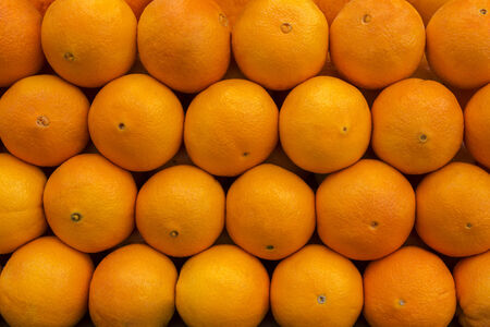 Many fresh raw oranges on a marketの写真素材