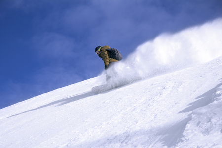 Snowboard freerider in the mountains with blue sky in the backgroundの写真素材