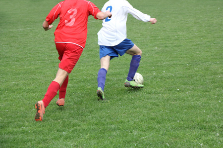 Soccer or football players in action on the field, blurred in motionの写真素材