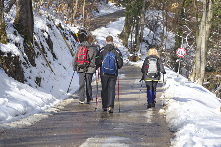 Rear view on mountaineers while walking in the snow forestの写真素材