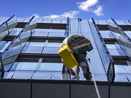 Climber wash windows and glass facade of the skyscraperの写真素材