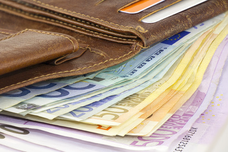 A bundle of Euro banknotes in a brown leather walletの写真素材