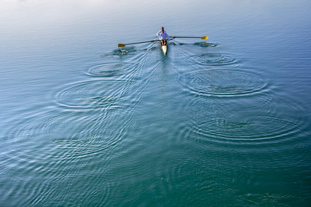 Two Man in a boat, rowing on the tranquil lake