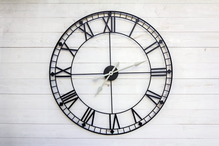 Old roman numeral clock on a wooden background