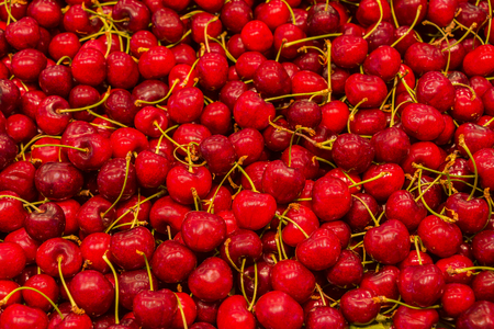 Fresh sweet cherries at the market as backgroundの写真素材