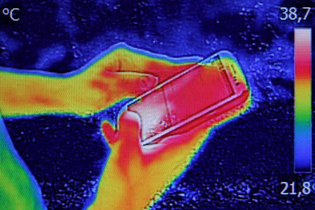 Infrared thermography image showing the heat emission when Young girl used smartphone or cell phone