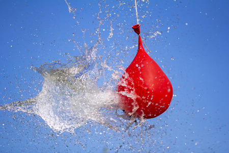 Explosion of balloon full of water on sky backgroundの写真素材