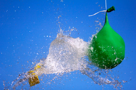 Explosion of balloon full of water on sky backgroundの写真素材