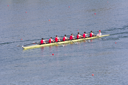 Rowers in eight-oar rowing boats on the tranquil lakeの写真素材
