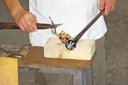 Glass worker makes glass sculptures in glass factory in Murano, Venice, Italyの写真素材