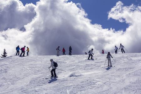 Skiers on mountainside  in the background lightの写真素材