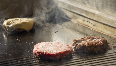 Preparing burgers at the barbecue outdoorsの写真素材