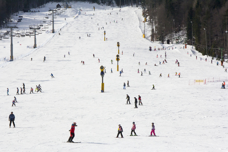 Lots of skiers and snowboarders on the slope at ski resortの写真素材