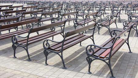 Lot of Rows of empty brown wooden benchesの写真素材