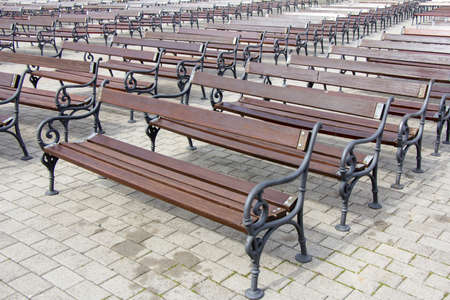 Lot of Rows of empty brown wooden benchesの写真素材