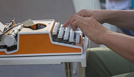 Young man working on old vintage manual typewriterの写真素材