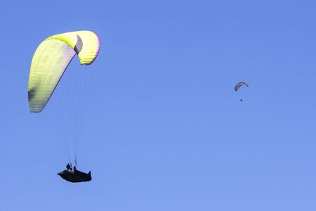 Paragliding in the blue sky as background extreme sportの写真素材