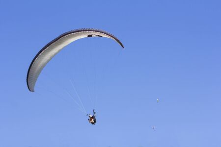 Paragliding in the blue sky as background extreme sportの写真素材