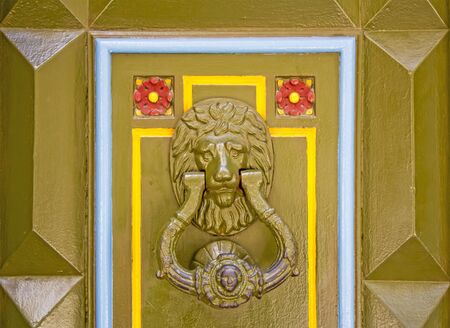 Old metal doorknob in the shape of lion head on old wooden doorの写真素材