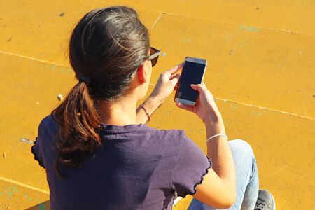 Young girl watching smart mobile phonの写真素材