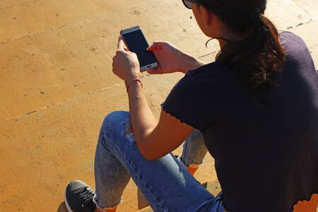 Young girl watching smart mobile phonの写真素材