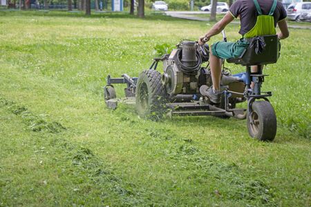 Worker mowing grass in a city park.の写真素材