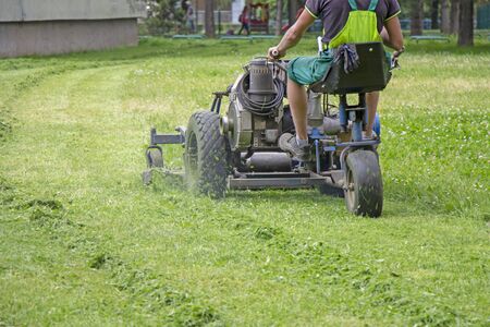 Worker mowing grass in a city park.の写真素材