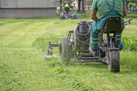 Worker mowing grass in a city park.の写真素材