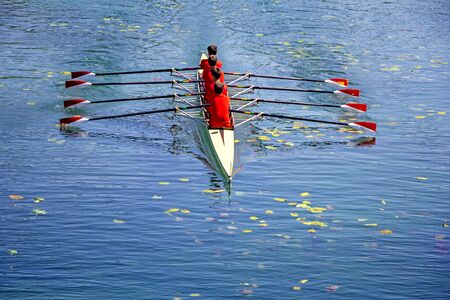 Men's quadruple rowing team on blue water, top viewの写真素材