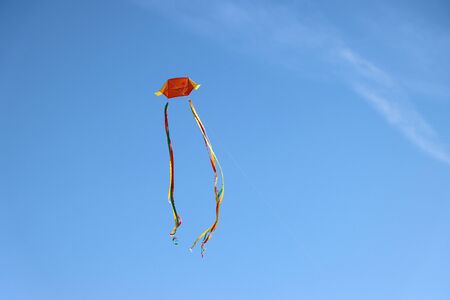 Colorful kite flying and blue sky as backgroundの写真素材