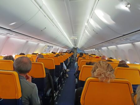 People are sitting in an airplane cabin during flightの写真素材