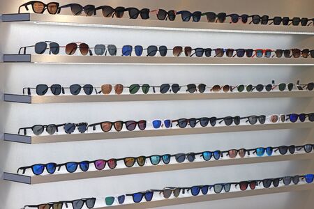 A lot of sunglasses on the wall showcase.の写真素材