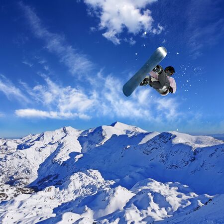 Skier Snowboarder jumping through air with blue sky in background
の写真素材