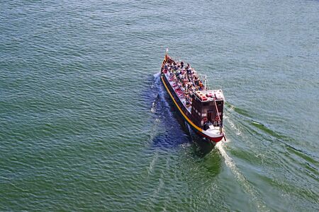 Tourist boat moving on The Duoro river in Porto view from above の写真素材
