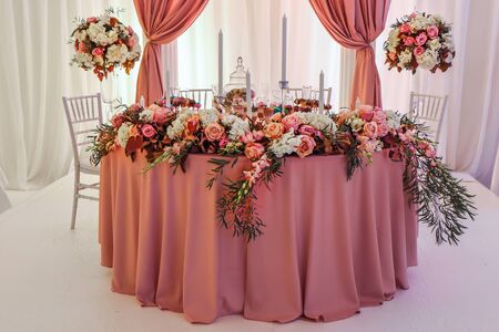Beautifully decorated wedding table with flowers and candlesの写真素材