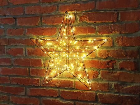 Shining yellow star on a brick wallの写真素材