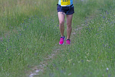 Young woman running in nature on a rural roadの写真素材