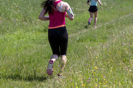 Young women running in nature on a rural roadの写真素材