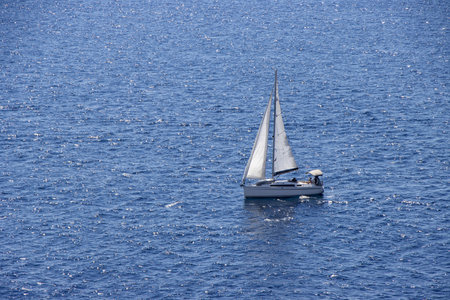 Sailingboat with white sails at opened seaの写真素材